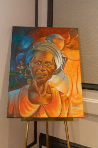 “Grann Tèt Mare Haitian painting of an elder woman with headwrap and pipe, symbolizing wisdom and heritage.”