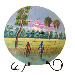 “Hand-painted round Haitian art plate depicting women walking through green fields under a pastel sky”